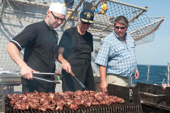 oseph Nader, retired Army Maj. Gen. Guy Bourn and retired Navy Capt. Byron BoCulinary Specialist 3rd Class Joth barbeque food during a steel beach picnic provided by members of the Steak Team Mission aboard the guided-missile cruiser USS Hué City (CG 66). Hué City is deployed to the U.S. 5th Fleet area of responsibility conducting maritime security operations, theater security cooperation efforts and support missions as part of Operation Enduring Freedom.