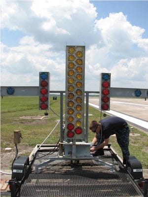 ET3 Ryan McCracken of NAS Jacksonville Ground Electronics performs corrosion control and maintenance work on the Manually Operated Visual Landing Aid System at Outlying Landing Field Whitehouse.