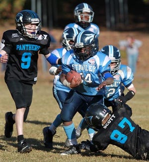 Mike Hensdill/The Gazette The Junior Pee Wee Stanley Blue Devils are heading to Florida to compete for the Pop Warner Super Bowl this Saturday. Here, DeAngelo Burton breaks a tackle during playoff action on Nov. 3.