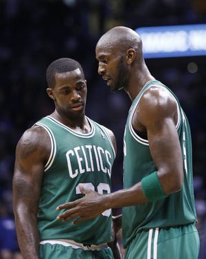 Celtics power forward Kevin Garnett (5) talks with teammate Brandon Bass (30) during the second half of Sunday's win in Orlando.