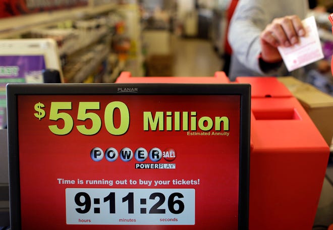 Store clerk Keyur Patel pulls a Powerball ticket that was dispensed from a machine in a convenience store in Baltimore, Wednesday, Nov. 28, 2012. There have been no Powerball winners since Oct. 6, and the jackpot has grown into the second highest in lottery history, behind only the $656 million Mega Millions prize in March.