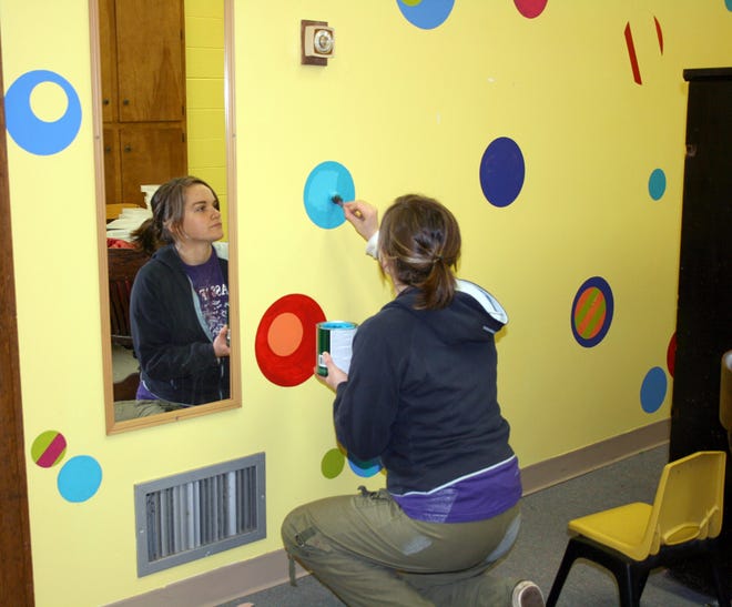 Volunteer Emily Ferguson helps put finishing touches of paint in one of the children's play areas in the basement of the former First Baptist Church in Ionia. The church was donated to The Well Church for the congregation's use.