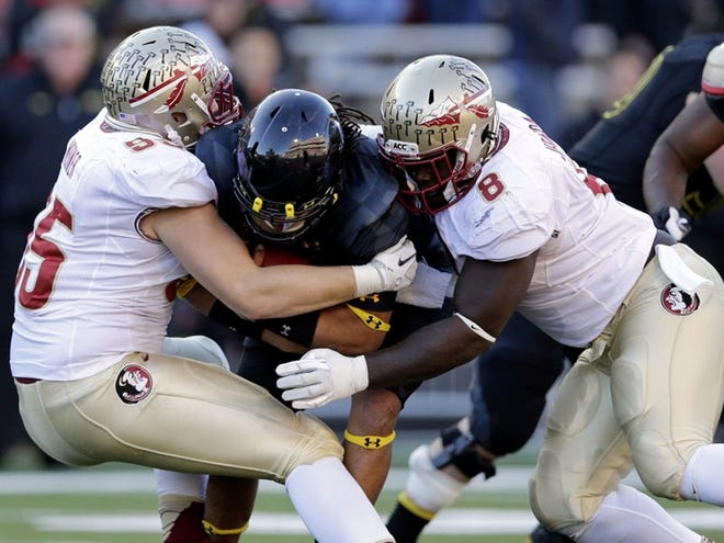 Maryland quarterback Shawn Petty, center, is tackled by Florida State defensive end Bjoern Werner, left, and defensive tackle Timmy Jernigan for a loss in the second half of an NCAA college football game in College Park, Md. Saturday, Nov. 17, 2012