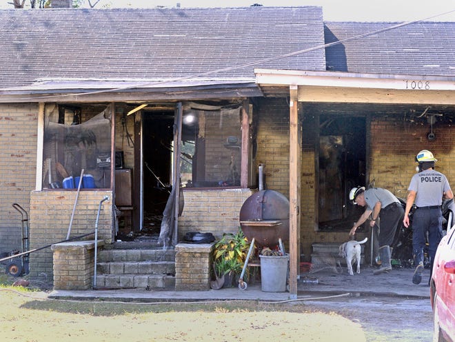 State Fire Marshal investigators and a K-9 go into a house at 1008 Second St. S.E. in Mulberry that caught on fire Friday morning.