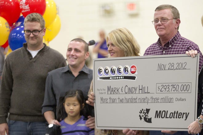 Mark and Cindy Hill hold a Powerball check with their three of their four children, Jarod, left, Cody and six-year-old Jaiden in Dearborn, Mo., Friday, Nov. 30, 2012.