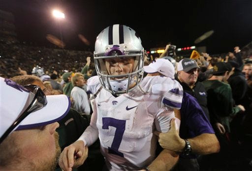 Kansas State quarterback Collin Klein is escorted through the crowd of Baylor fans who mobbed the field after the Bears handed K-State its first loss in 11 games, a 52-24 setback in Waco that put a severe dent in Klein's Heisman Trophy prospects.
