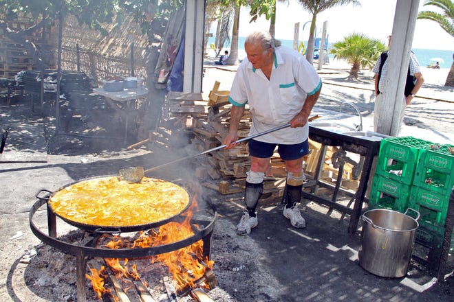 At Nerja, on Spain's Costa del Sol, there's a lunchtime seaside feast every day at Ayo's bar, where he cooks paella over an open fire. (Photo by Rick Steves)