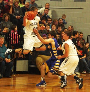 Fieldcrest freshman Drew Barth gets airborne while trying to keep the ball in play Friday night against Tri-Valley in Minonk. Fieldcrest won the HOIC contest 62-49. Looking on for the Knights is Jackson Puetz.