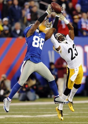New York Giants wide receiver Hakeem Nicks (88) and Pittsburgh Steelers cornerback Keenan Lewis (23) fight for control of the ball during the first half of an NFL football game, Sunday, Nov. 4, 2011 in East Rutherford, N.J. (AP Photo/Bill Kostroun)