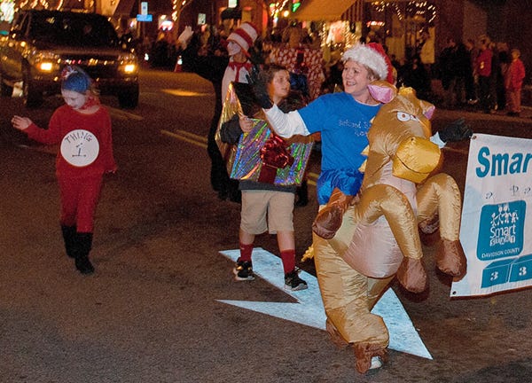 Costumed paraders from Smart Start of Davidson County wave as they pass through the Square on Monday night during the Lexington Jaycees Annual Christmas Parade.