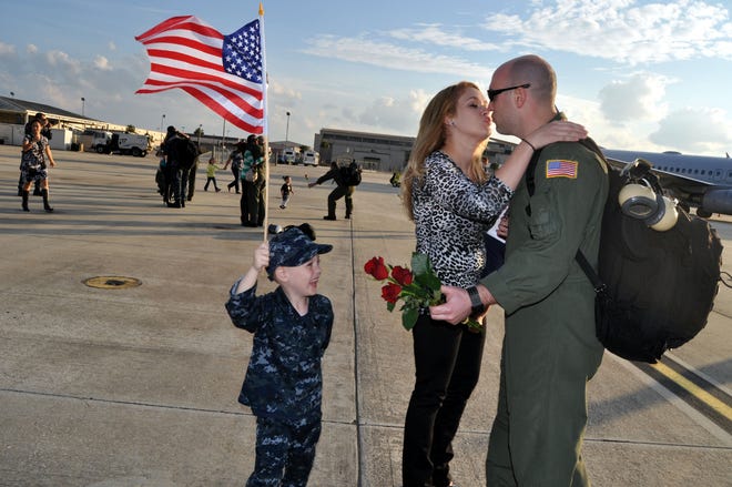 AWO2 Charles Seacrist of VP-8 happily greets his wife, Brooke as their 5-year-old son, Jaxon excitedly waits for a hug from his dad who returned home on Nov. 27 after a six-month deployment to El Salvador.