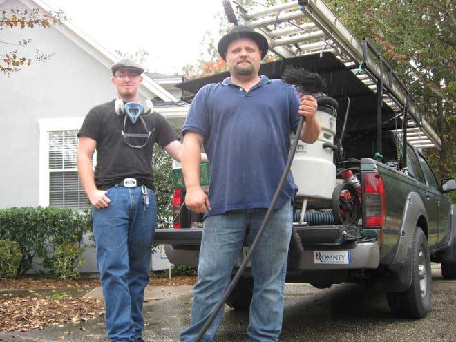 Michael Davis (right) and his assistant Matthew Morris still clean chimneys with Ash Away Chimney Service based in Macclenny. They sometimes still use traditional chimney sweep gear such as wire brushes.