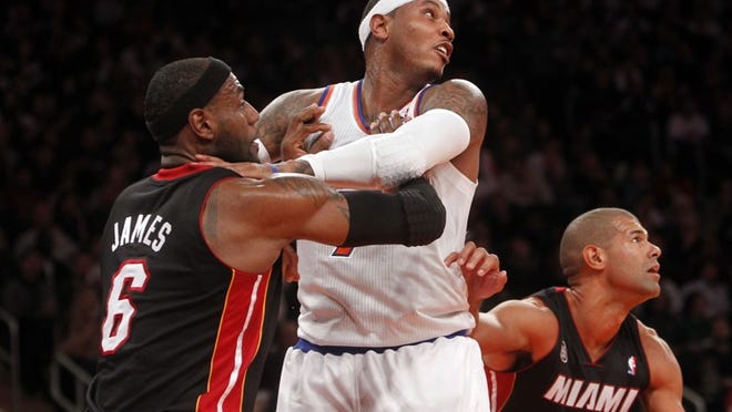 New York Knicks' Carmelo Anthony (7), center, grapples with Miami Heat's LeBron James (6), left, and Shane Battier (31) during the first half of an NBA basketball game, Friday, Nov. 2, 2012, in New York. New York defeated Miami, 104-84. (AP Photo/Jason DeCrow)