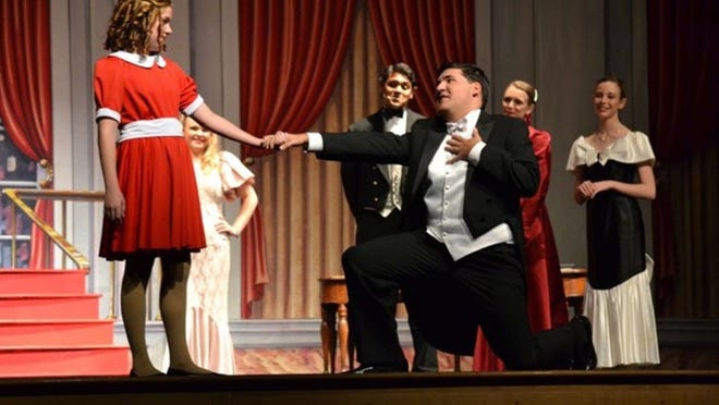 Summer McCarty (left) had the title role, and Bernie Pino played Mr. Warbucks when students at The King s Academy staged the musical “Annie.” The production included several high school students playing the adult roles, as well as more than 120 elementary and middle school students in the orphan choruses.