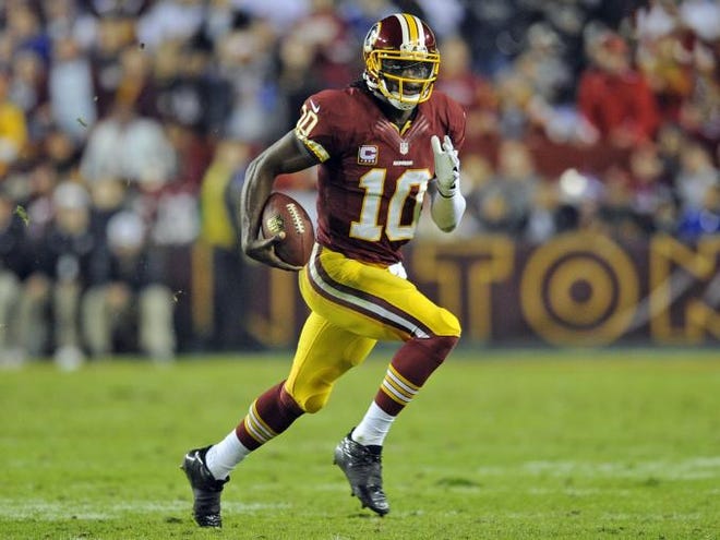 Washington Redskins quarterback Robert Griffin III scrambles with the ball during the second half of an NFL football game against the New York Giants in Landover, Md., Monday, Dec. 3, 2012.
