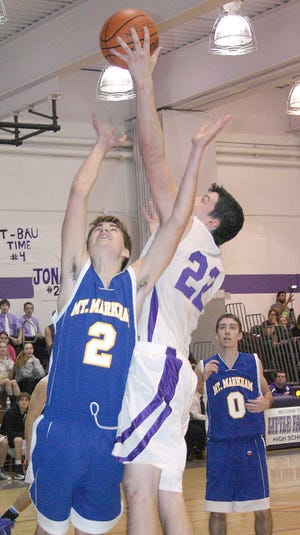 Jesse Lonis reaches over Mt. Markham’s Mike Alsante (2) to grab one of his 19 rebounds for the Little Falls Mounties Thursday