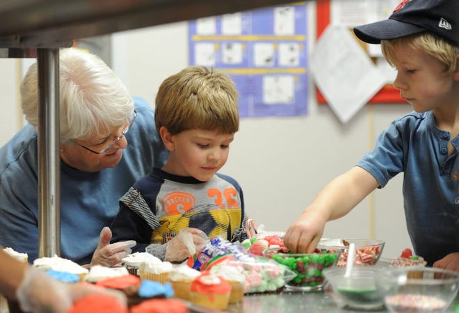 Fran Ruddock helps three-year-old Josiah Mansker, center, with decorating a cupcake as brother Cayden Mansker, 5, all from Brewster, looks on. The Manskers are the sons of Cape Cod Bible Alliance Church Youth Pastor Derek Mansker and his wife, Jenny Mansker. Youths from Cape Cod Bible Alliance Church, the church that burned down last week, baked cookies and cupcakes for local fire departments who helped with extinguishing the fire. They baked them at the Harwich Community Center.
