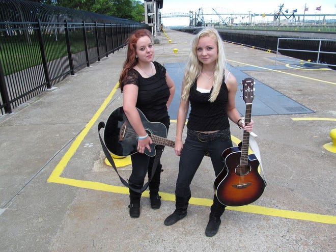 Up-and-coming singer/songwriters Missy Zenker (right), 17, and Chelsea Zenker, 15, of Sault Ste. Marie pose with their guitars at the Soo Locks.