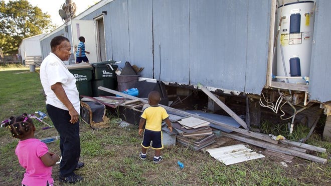 Ethel Wright watches Makhia Foster, 2; Virgil “Petey? Crawford, 8; and Michael Foster, 2, in the backyard of their mobile home. Their home is falling apart, but a donor is looking for a new one for them.