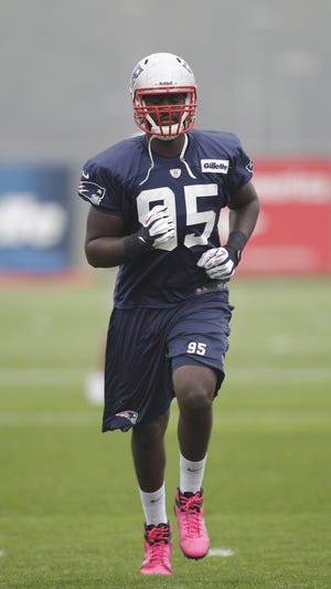 Patriots defensive end Chandler Jones runs during a stretching drill in Foxboro on Wednesday.