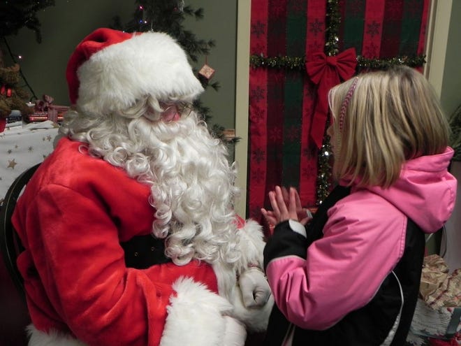 Santa listens to the recitation of a Christmas list at last year's Christmas by the River. This year's event begins at 5 p.m. Thursday in downtown Lyons.