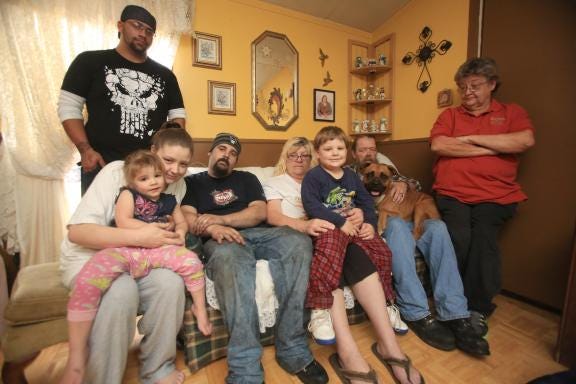 Andrew Herndon, left to right, Jersey-Lynn Haley, 2, Jennifer and Joe Haley, Teresa Poteat, Joseph Haley, 4, Dale Poteat and their dog Bear are all staying with Dale's sister Jackie Steen after their home caught on fire December 3rd causing the family to lose all of their belongings. (Ben Earp/The Star)