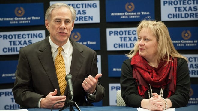 Texas Attorney General Greg Abbott (left) and Amanda Van Hoozer, director of program services at the Center for Child Protection, hold a news conference Tuesday, Dec. 11, 2012, to announce a public service campaign to help Texans recognize signs of child abuse. A public service announcement featuring the head football coaches of the University of Texas, Texas A&M University and the University of Houston was previewed.