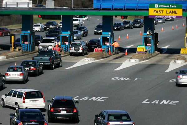 Drivers go through the Route 128 and I-90 Massachusetts Turnpike tolls during rush hour in Natick in this file photo.