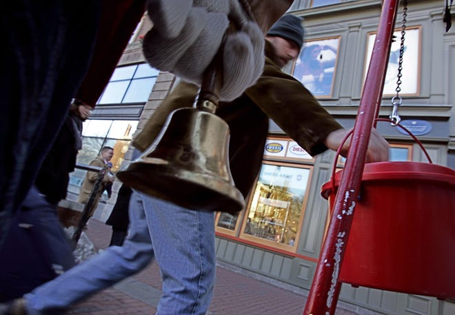 A passer-by puts money into a red Salvation Army kettle in Cambridge.
