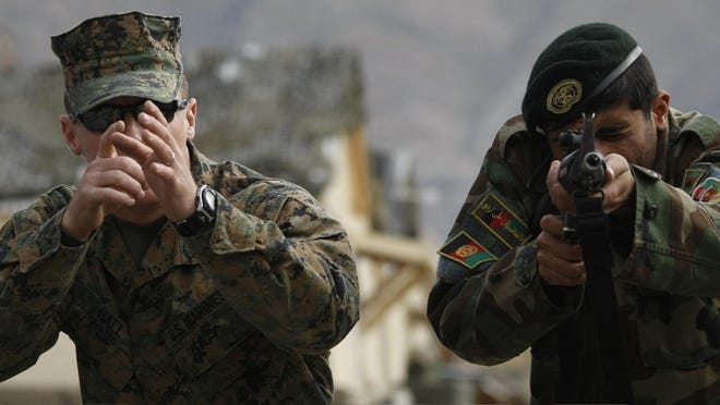 U.S. Marine Sgt. Terry Hall teaches an Afghan soldier Saturday. As the U.S. commits more troops, Afghan President Hamid Karzai is under Obama administration pressure to clean up his government.
