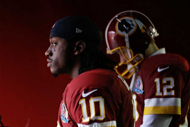 Washington Redskins quarterbacks Robert Griffin III and Kirk Cousins walk through the tunnel to the field before a game against the Baltimore Ravens on Dec. 9 in Landover, Md. (Patrick Semansky/AP)