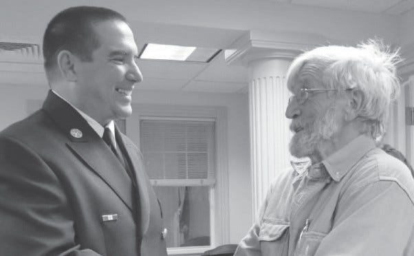 Leroy “Skip’’ Clark, chairman of the Board of Selectmen, greets new fire chief Bradley Weber.