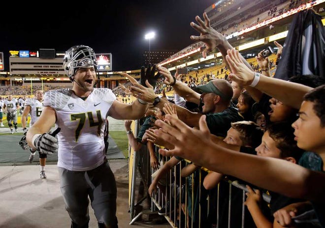 Oregon senior guard Kyle Long high-fives Duck fans on his way out of the stadium after defeating Arizona State in Tempe earlier this season. Long has appealed to the NCAA for another year of eligibility, but the Fiesta Bowl may be his last game.