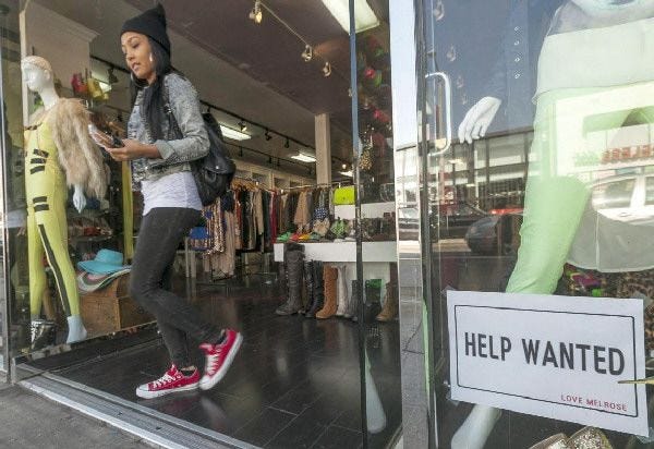 A help wanted sign is posted on the front window of a clothing boutique in Los Angeles on Friday.