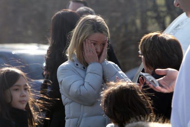 A woman weeps as she arrives to pick up her children at the Sandy Hook Elementary School, Friday, Dec. 14, 2012 in Newtown, Conn. A man opened fire inside the Connecticut elementary school where his mother worked Friday, killing 26 people, including 18 children, and forcing students to cower in classrooms and then flee with the help of teachers and police. (AP Photo/The Journal News, Frank Becerra Jr.)