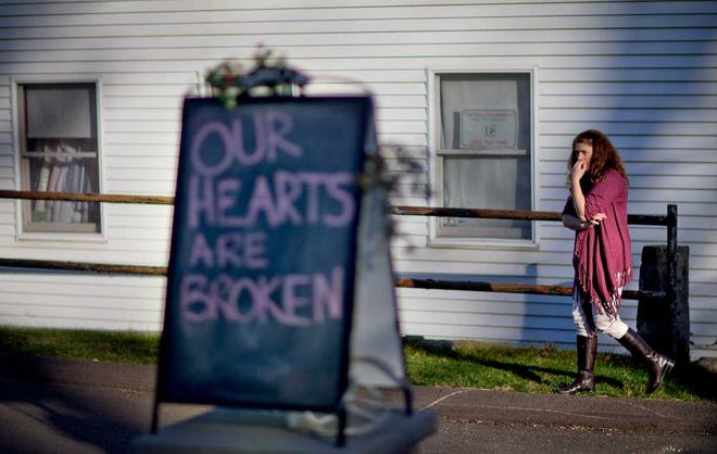 Shop owner Tamara Doherty paces outside her store Saturday just down the road from Sandy Hook Elementary School. The massacre of 26 children and adults at the school elicited horror and soul-searching around the world.