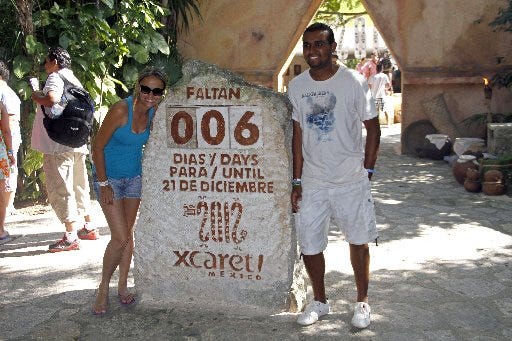 Tourists get their picture taken next to a slab of stone counting down the days until Dec. 21, 2012 at the Xcaret theme park in Playa del Carmen, Mexico, Saturday, Dec. 15, 2012.