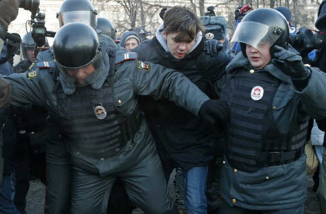Police officers detain an opposition activist during an unauthorized rally in Lubyanka Square Saturday in Moscow.