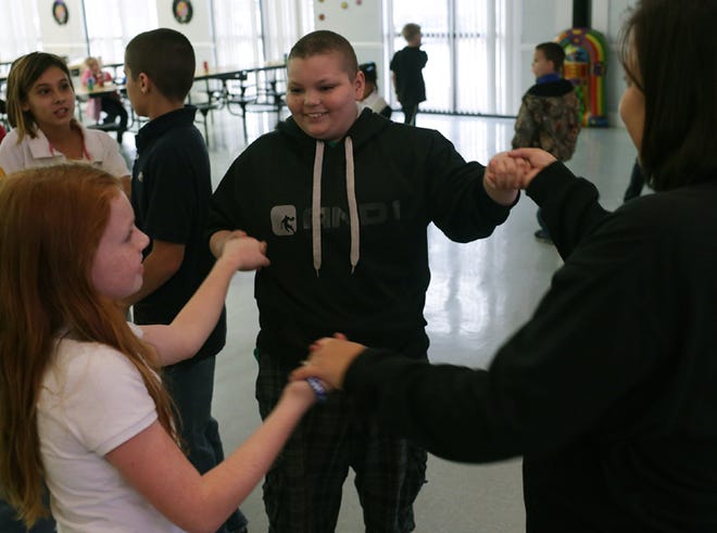 Brennan Campbell dances with students and his teacher Sonia Reeves during a welcoming party for him at Oakland Terrace School in Panama City, Fla. on Friday
