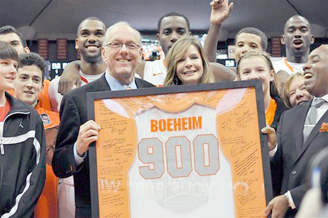 Syracuse coach Jim Boeheim, joined by his wife, Julie, is presented with a jersey for his 900th career win, after Syracuse defeated Detroit 72-68 Monday.