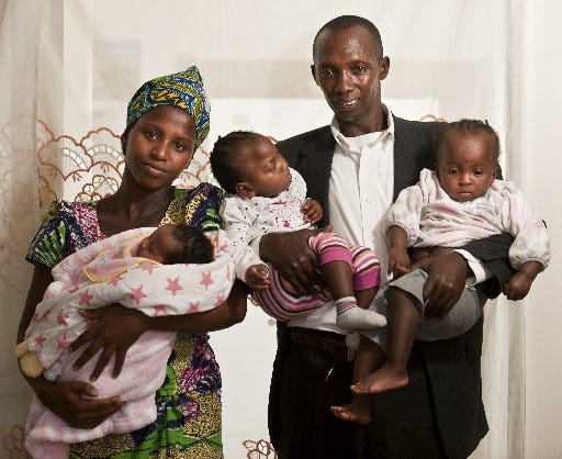 Nzabo Sanga and his wife, Nyirakamana Gateyeneza, hold their children Lilian (from left), age 2 weeks, and twins Josee and Germaine, 19 months. They are refugees from the fighting in Africa.