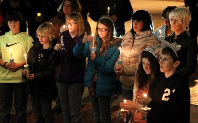 (John Clark/The Gazette) People listen to coments from Gaston County Schools Superintendent Reeves McGlohin during the candlelight vigil Tuesday night at the Rotary Pavillon in Gastonia in remembrance of those killed at Sandy Hook Elementary School in Newton, Conn.