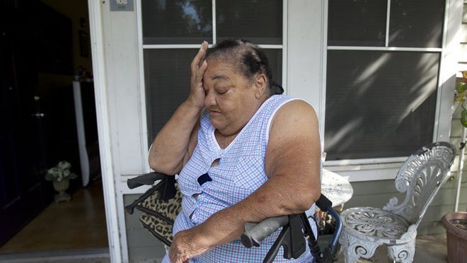 María González Bolanos, a 71-year-old Cuban refugee, sits on the porch at her home. Bolaños has trouble walking so she spends most her her days in bed watching television. She is currently living off $62 monthly charity check provided by National Church Residences. She needs a knee surgery to get back on her feet.