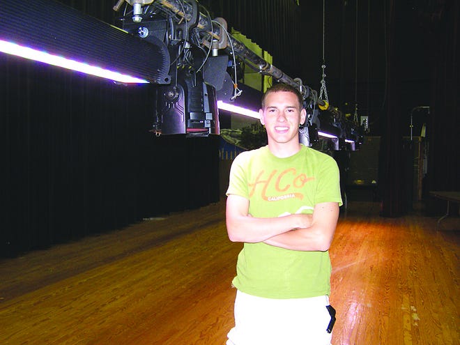 Austin Stoler stands next to a suspended lighting pipe backstage at Greencastle-Antrim High School. His knowledge of the prototype system came in handy when the contractor needed details explained to Millersville University.