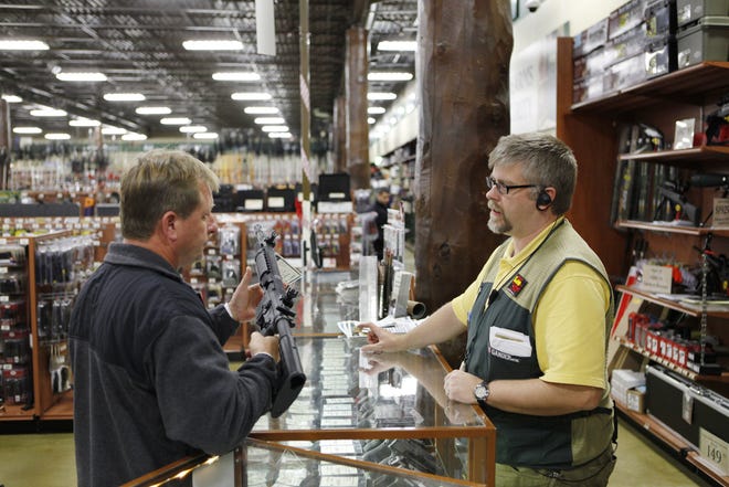 Will Petersen, a manager who oversees the gun department at Gander Mountain in Springfield, answers questions for Jeff Stelle who was looking at guns Wednesday, Nov. 21, 2012. Petersen is among the store's employees who will be on duty Thanksgiving Day.