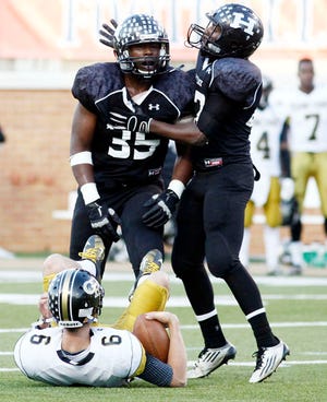 Havelock senior Malcom Ashley, left, and Anthony Fisher celebrates Ashley's sack of Concord QB B.J. Beecher during the 3A state championship game in Winston-Salem.