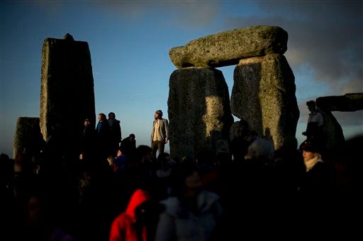 People soak up the sun after its rise at the ancient stone circle of Stonehenge, in southern England, as access to the site is given to druids, New Age followers and members of the public on the annual Winter Solstice, Friday, Dec. 21, 2012.