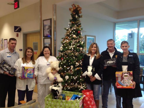 Blue Marlin Realty Group’s Leslie Sullivan (third from right) and Jennifer Hughes (far right) with the Sacred Heart Hospital Emergency Room staff upon delivery of toys.