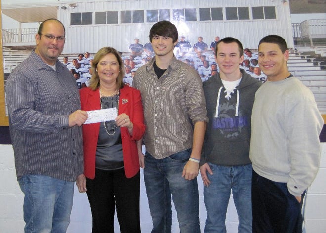 Michael Del Corso from the Cavalier Football Club presents a check for $260.80 to Carole Ann Bower from Hope for Strength Breast Cancer Fund. Also pictured are football players Tyler McLaughlin, Scott Barrett and Cameron Capote.