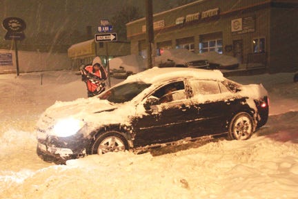 Dan and Lynn Shumbarger work to free a vehicle from the intersection of Ashmun and Ann early this morning. With approximately 12 inches of snow falling on Sault Ste. Marie and the surrounding area over a 24-hour period there were plenty of others across the region engaged in similar activities early this morning.